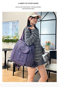 Detail of purple nylon shoulder bag showing adjustable strap and side pocket design