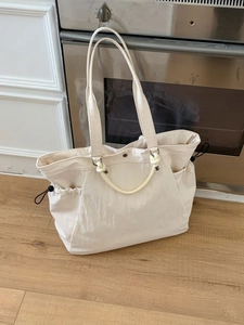 Minimalist beige large tote bag with rope knot handle and drawstring side pockets