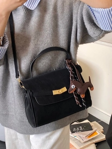 Classic black leather crossbody bag with golden hardware and cute dog charm decoration