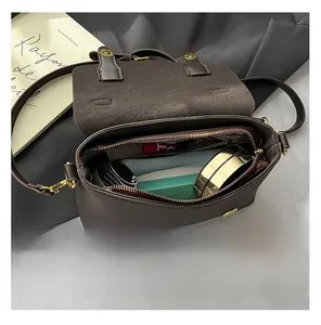 Interior view of brown crossbody bag showing storage space for phone and makeup items