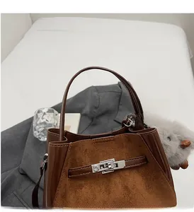 Dettaglio della borsa a secchiello marrone con fibbia argento e ciondolo di peluche