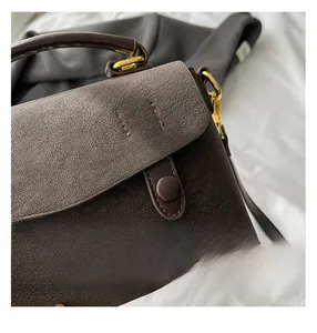Detailed macro view of dark brown cracked leather texture with gold metal hardware