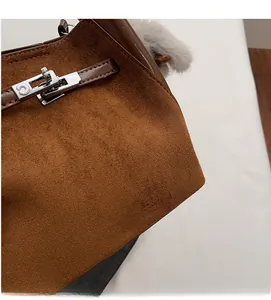 Dettaglio della borsa a secchiello in pelle scamosciata marrone con chiusura a scatto