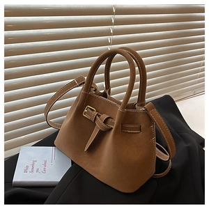 Detail of brown suede bucket bag with gold buckle on a classic vintage handbag