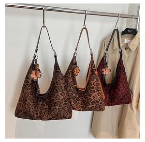 Detail of leopard print hobo bags with leather straps and flower charms in three colors