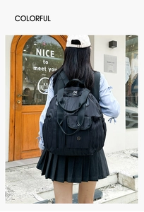 Detail of black quilted backpack featuring wrinkled texture and convenient front flap pocket