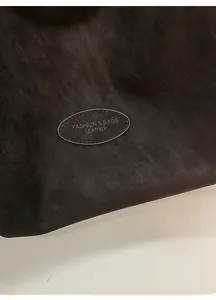 Detail of soft black synthetic leather texture and fashion embossed oval logo patch