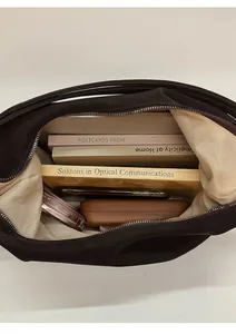Detailed view of spacious interior of a vintage hobo tote bag with multiple items
