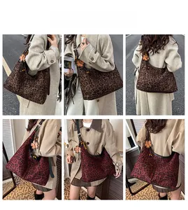 Detail view of large leopard print hobo bags with flower charms and leather straps