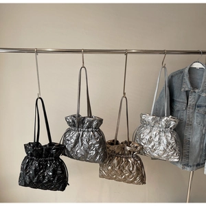 Close-up of quilted puff tote bags in metallic black, grey, gold and silver finishes
