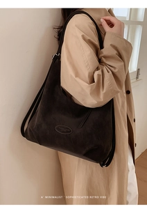 Detail der minimalistischen schwarzen Hobo-Tasche mit Vintage-Lederstruktur und Label