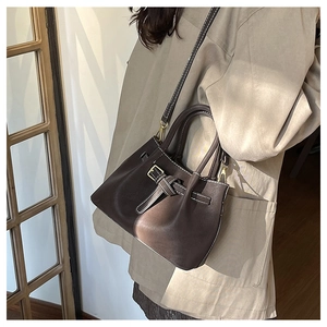 Détails du sac seau en cuir mat marron foncé avec surpiqûres blanches contrastées
