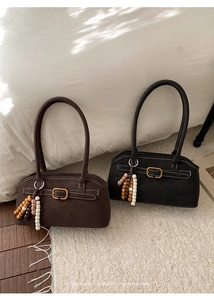 Detail von Retro-Wildledertaschen mit Metallschnallen und farbigen Perlenanhängern