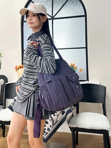 Deep purple quilted nylon shoulder bag with multiple pockets and a wide canvas strap