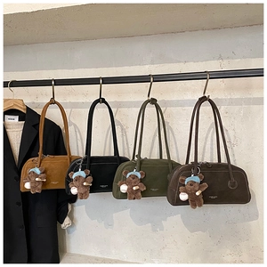 Détail de quatre sacs Boston rétro en daim de plusieurs couleurs avec pendentifs ours