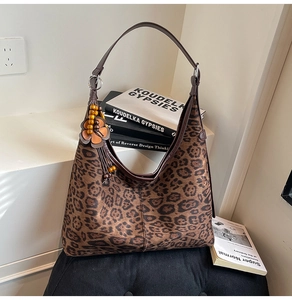 Detail of leopard print tote bag with vintage wood bead charm and autumn styling