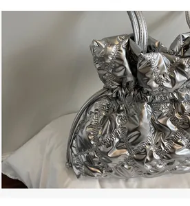 Detailed view of silver quilted bucket bag with metallic finish and drawstring closure