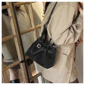 Detail of vintage black bucket bag with contrast white stitching and decorative buckle