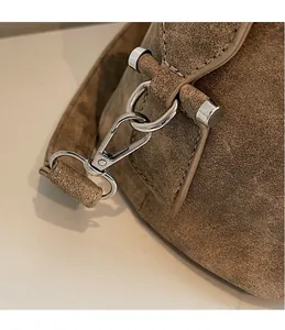 Dettaglio della ferramenta in metallo argento e moschettone sulla borsa in pelle marrone