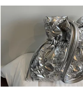 Detail of silver quilted drawstring bag with metallic texture and diamond pattern