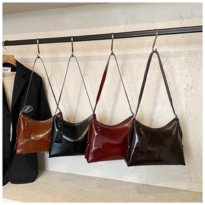 Detail of four glossy faux leather tote bags in brown, black, burgundy, and dark coffee