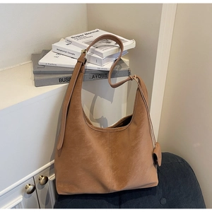 Detail of vintage brown tote bag with leather texture and matching mini pouch pendant