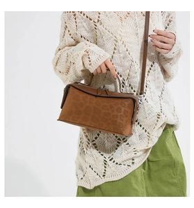 Close-up of brown leopard embossed handbag with silver hardware and shoulder strap