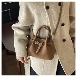 Detailed shot of brown vintage bucket bag with contrast stitching and leather strap detail