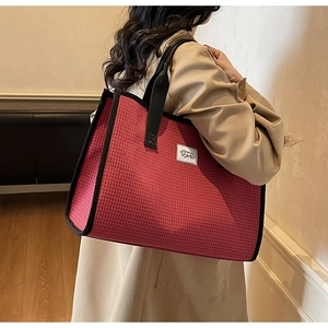 Large red checkered tote bag shown on model highlighting spacious capacity and style