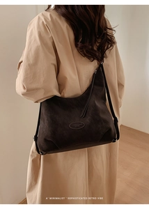 Macro detail of dark brown suede tote bag with vintage minimalist oval logo patch