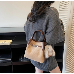 Dettaglio della borsa a secchiello con chiusura in metallo e ciondolo a forma di coniglio bianco
