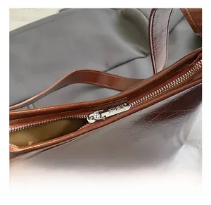 Detailed close-up of premium brown oil wax leather tote bag with silver metal zipper