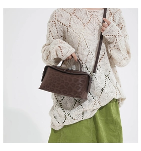 Détail d'un sac à main vintage marron foncé à motif léopard avec poignée et bandoulière