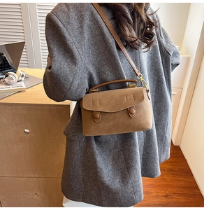 Detail of vintage dark brown crossbody bag in textured faux leather on a model's shoulder