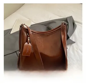 Macro shot of retro brown oil wax leather tote bag with embossed fashion tag