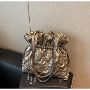 Detail of champagne gold quilted puffer bag texture with drawstring closure