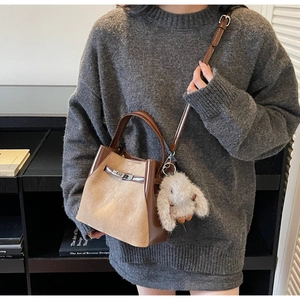 Borsa a secchiello vintage con inserti in pelle scamosciata, chiusura metallica e ciondolo