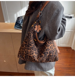 Leopard print tote bag detail showing brown leather straps and flower charm