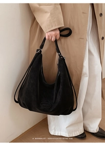 Detailansicht der schwarzen Hobo-Tasche aus Wildlederimitat mit Logo und Retro-Vibe