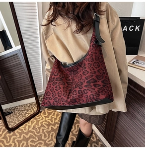 Detailed view of large burgundy leopard print hobo bag with black leather trim and strap