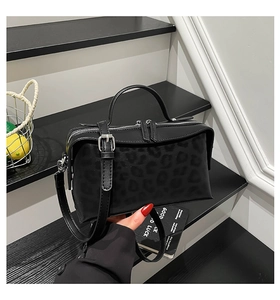 Détail du sac à main noir à motif léopard avec quincaillerie argentée et double fermeture éclair