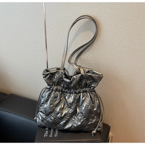 Detail of silver metallic quilted bucket bag with drawstring closure and fine strap
