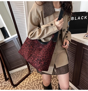 Detailed view of leopard print crossbody bag with black leather trim worn by model