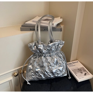 Close-up of metallic silver quilted tote bag with drawstring closure and diamond stitching