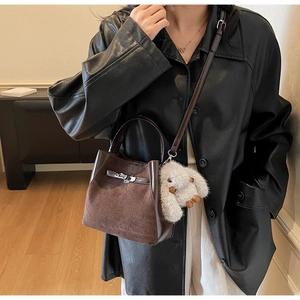 Dettaglio borsa a secchiello vintage in pelle scamosciata e fibbia in metallo classica