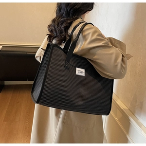 Gros plan d'un cabas à carreaux montrant l'étiquette I BAGS et la texture du tissu