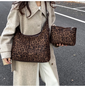 Detailed view of leopard print dumpling bag and matching pouch worn on a shoulder strap