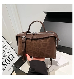 Détail du sac bandoulière léopard vintage avec cuir marron et boucles en métal argenté