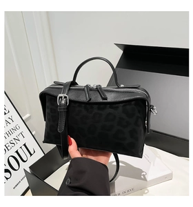 Détail du sac léopard avec double fermeture éclair argentée et poignée supérieure lisse