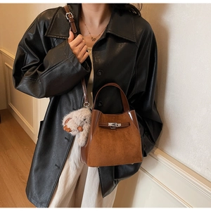 Borsa a secchiello marrone in camoscio e pelle con fibbia in metallo e charm